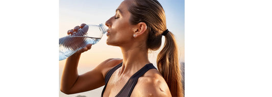 Exercise & Skin Health blog post image of sweaty woman who seems to have been exercising, taking a break to drink some water