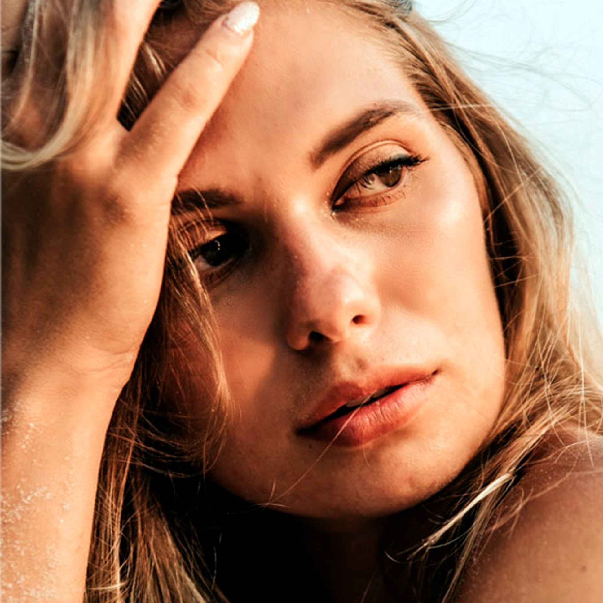 Close up of woman with blond hair, brown eye with radiant skin.