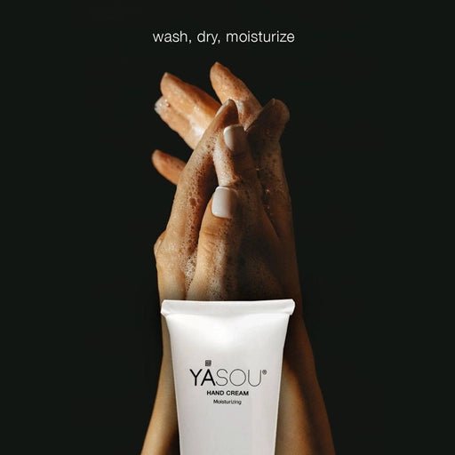 Woman washing her hands folded with top part of vegan hand cream tube.