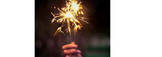 Close up of hand holding a  sparkler for YASOU's blog post called "7 New Year Skin Care Resolutions".