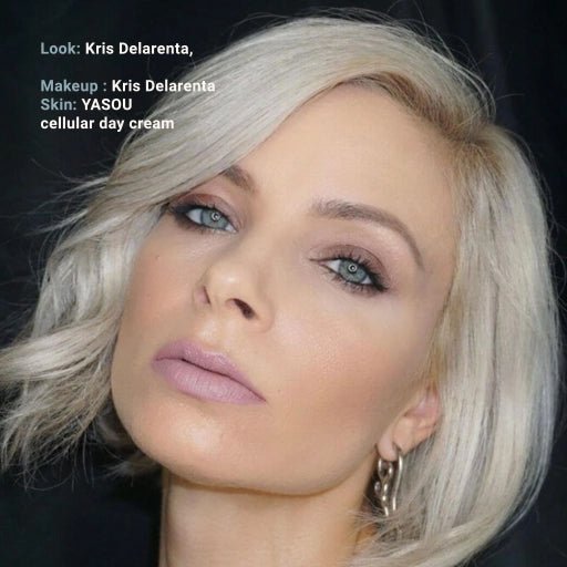 Close-up of a person with blonde hair and makeup, with text indicating the look and makeup by Kris Delaerenta. skin - YASOU cellular day cream.