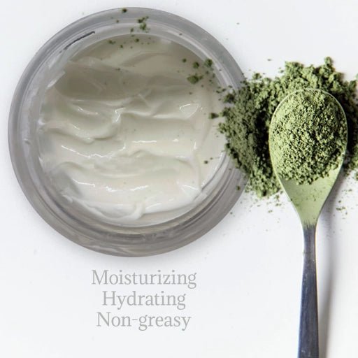 Jar of white cream with a spoonful of green tea powder on a white background listing skin benefits.